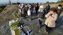 Sejumlah orang berdoa ke arah laut untuk mengenang para korban bencana gempa dahsyat dan tsunami besar di Jepang pada 11 Maret 2011 silam, di Minamisoma, Prefektur Fukushima, Jumat (11/3/2016). (REUTERS/Kyodo)