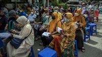 Warga menunggu giliran untuk menerima dosis vaksin booster COVID-19 Pfizer di Surabaya, Jawa Timur, Kamis (13/1/2022). (JUNI KRISWANTO/AFP)