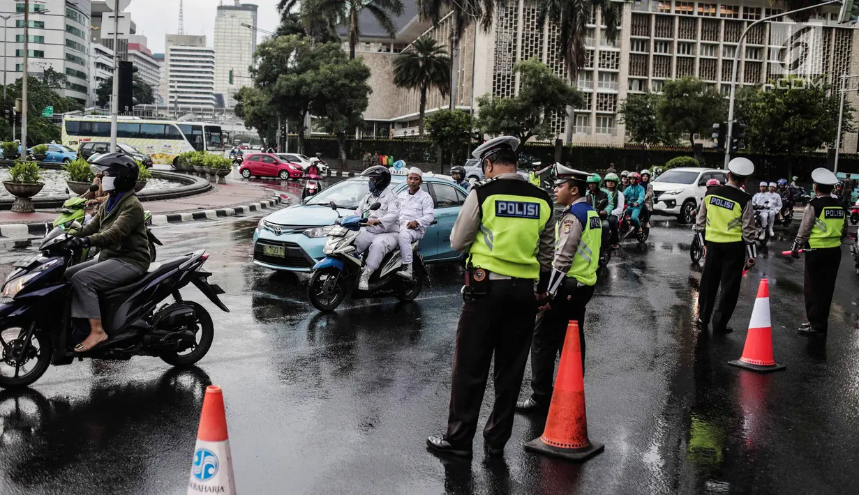 Polisi melakukan pengalihan arus lalu lintas terkait Malam Munajat 212 di Medan Merdeka Barat dan Utara, Jakarta, Kamis (21/2). Arus lalu lintas di sekitar kawasan Monas akan ditutup untuk mencegah kemacetan. (Liputan6.com/Faizal Fanani)