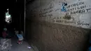 Tulisan protes terhadap penggusuran ditulis di tembok rumah warga di kawasan pemukiman Kampung Pulo, Jakarta Timur, Kamis (23/7). Pemerintah Provinsi DKI Jakarta akan menertibkan bangunan liar yang ada di wilayah Kampung Pulo. (Liputan6.com/Faizal Fanani)