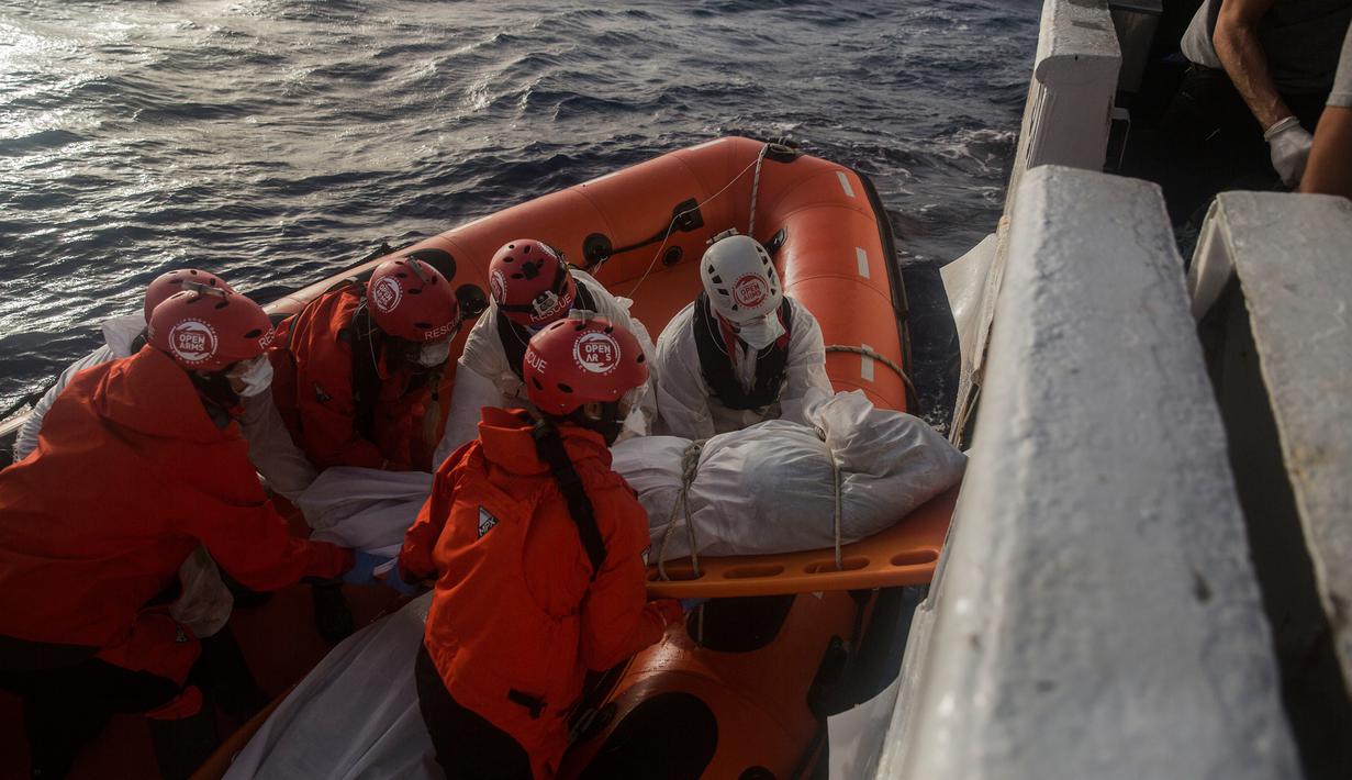 Petugas LSM Spanyol mengevakuasi mayat imigran Afrika sub-Sahara di tengah Laut Mediterania, lepas pantai Libya, Selasa (25/7). Petugas menemukan 13 mayat, termasuk ibu hamil dan anak-anak, di atas perahu karet yang membawa 160 migran. (AP/Santi Palacios)