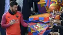 Bintang Barcelona, Lionel Messi, memberikan tanda tangan kepada fans usai mengikuti sesi latihan perdana tahun 2017. Selain La Liga, Barca juga masih berjuang untuk trofi Liga Champions tahun ini. (AFP/Lluis Gene)