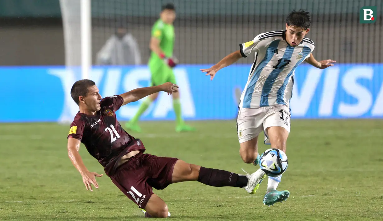 <p>Pemain Timnas Argentina U-17, Valentino Acuna (kanan) berebut bola dengan pemain Timnas Venezuela U-17, Nicola Profeta pada laga 16 besar Piala Dunia U-17 2023 di Stadion Si Jalak Harupat, Bandung, Selasa (21/11/2023). (Bola.com/Ikhwan Yanuar)</p>