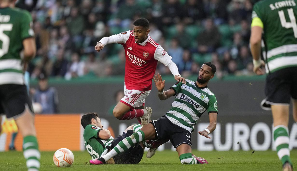 Pemain Arsenal, Reiss Nelson (tengah) berusaha melewati pemain Sporting CP pada laga leg pertama Liga Europa 2022/2023 di Jose Alvalade Stadium, Lisbon, Jumat (10/03/2023) dini hari WIB. Laga berakhir dengan skor imbang 2-2. (AP Photo/Armando Franca)