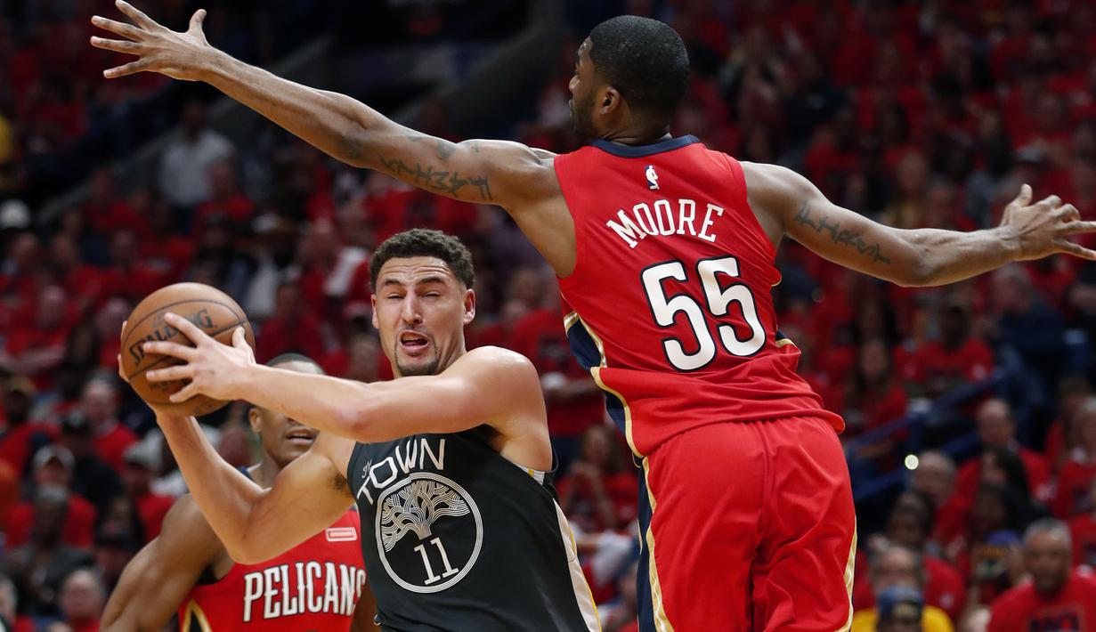 Pemain Warriors, Klay Thompson (11)  mencoba melewati adangan pemain Pelicans, E'Twaun Moore (55) pada laga gim ketiga semifinal NBA basketball playoff di Smoothie King Center, New Orleans, (4/5/2018). Pelicans menang 119-100. (AP/Gerald Herbert)