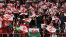 Fans cilik asal Wales membentangkan bendera kebangsaannya di tengah-tengah kerumunan tribun fans Austria. (Bola.com/Reza Khomaini)