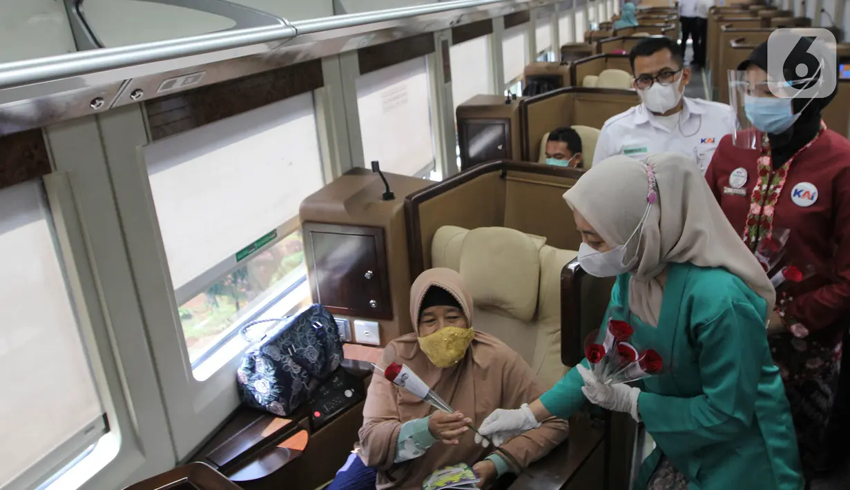 Petugas PT KAI Daop 1 Jakarta membagikan bunga kepada penumpang di Stasiun Gambir, Rabu (21/4/2021). PT KAI DAOP 1 memperingati Hari Kartini menginspirasi para penumpang agar semangat berjuang melawan pandemi COVID-19 dengan selalu menerapkan protokol kesehatan. (Liputan6.com/Herman Zakharia)