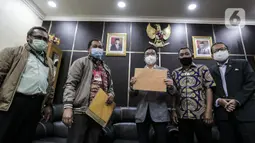 Koordinator MAKI Boyamin Saiman (kiri) menyerahkan salinan surat jalan Djoko Tjandra kepada Ketua Komisi III DPR Herman Herry di Kompleks Parlemen, Jakarta, Selasa (14/7/2020). MAKI meminta terpidana korupsi yang merugikan negara hingga Rp 904 miliar itu diusut tuntas. (Liputan6.com/Johan Tallo)