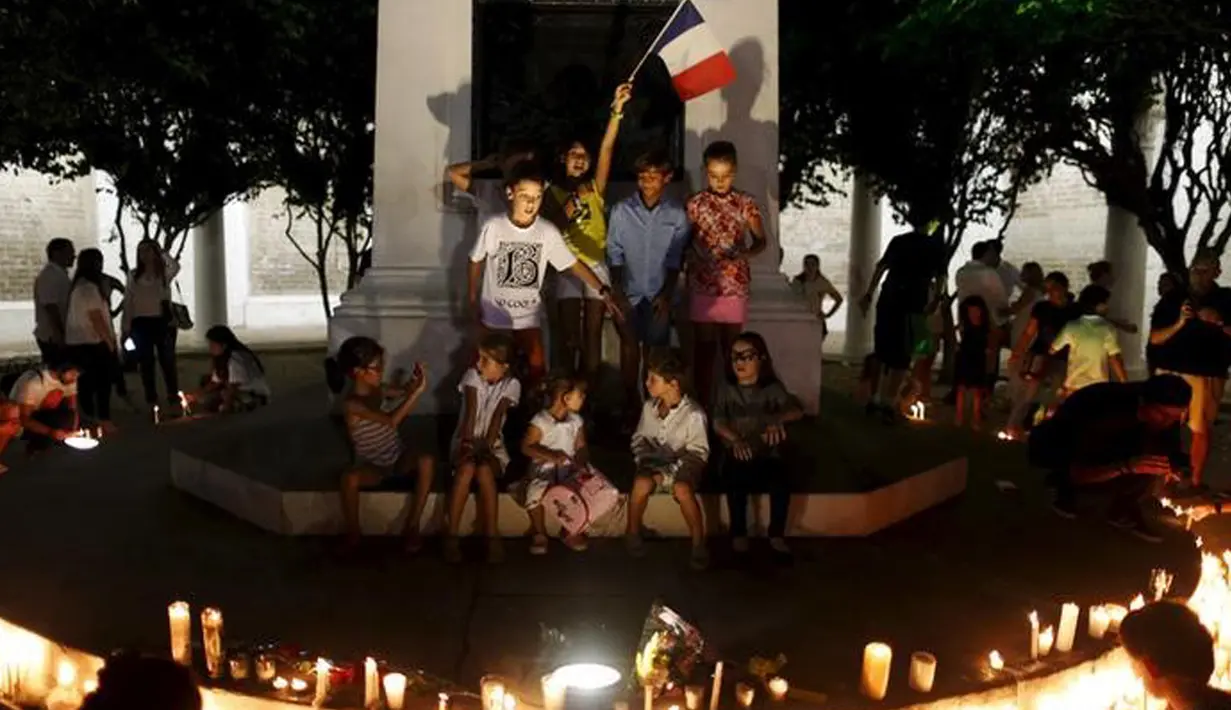 Sejumlah anak dan warga lainnya berkumpul di Plaza de Francia di Panama City, Panama, Sabtu  (14/11/2015). Mereka menata lilin - lilin untuk ikut berduka cita atas tragedi di Paris. (REUTERS/Carlos Jasso)