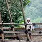 Seorang masyarakat Baduy Dalam melintas di jambatan bambu yang berada di kawasan Baduy Luar, Sabtu, 24/8/2024. (Syahrul Rahmat)