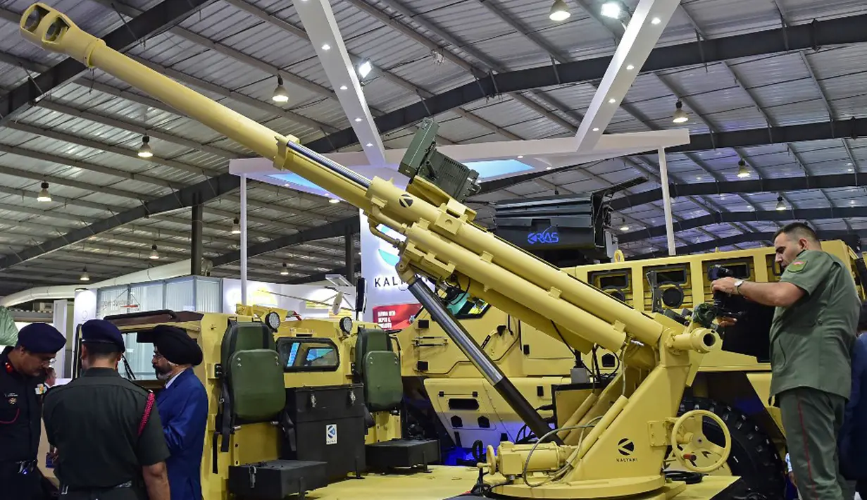 Pengunjung berdiri di samping sistem senjata Garuda 105 V2 yang dipasang pada kendaraan di Defence Expo 2022, Gandhinagar, India, 18 Oktober 2022. Defense Expo 2022 ini akan berlangsung selama lima hari. (Sam PANTHAKY/AFP)