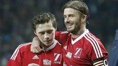 Pesepakbola David Beckham memeluk anaknya Brooklyn ketika mereka sedang bertanding bola dalam laga amal di Old Trafford, Inggris, Sabtu (14/11/2015). Dalam laga amal bertajuk Match for Children ini mengajak anaknya untuk ikut bermain. (Dailymail)