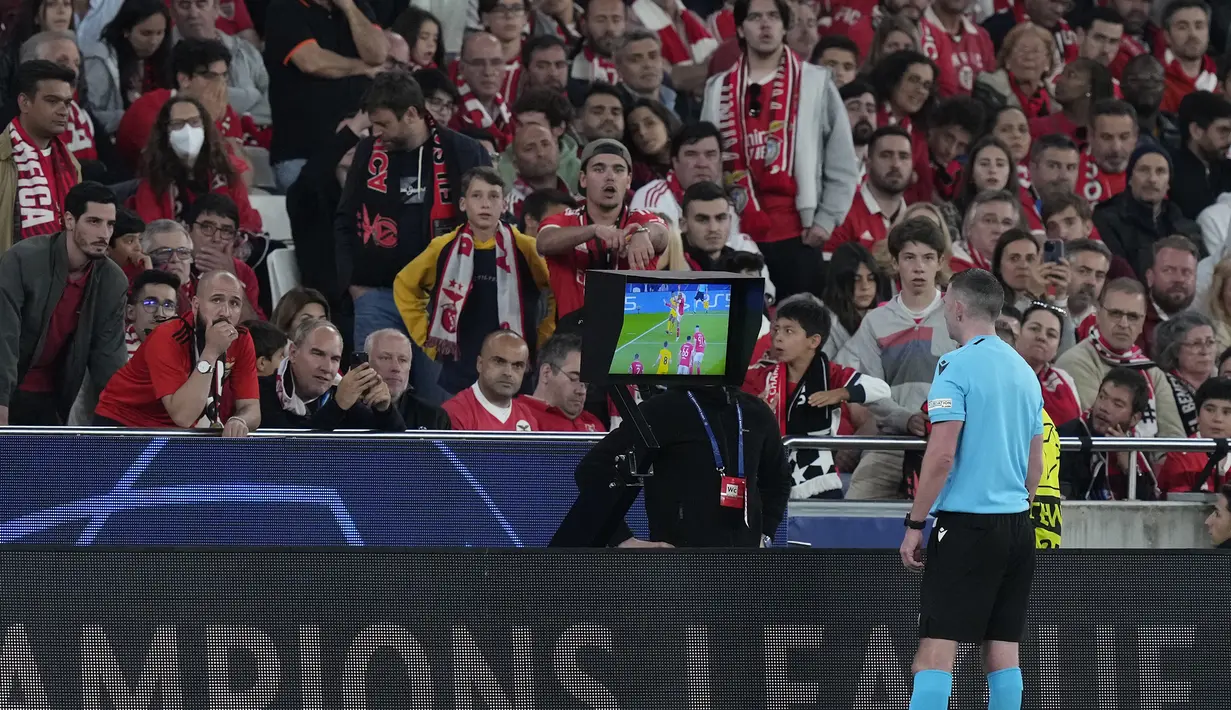 Wasit Michael Oliver mengamati VAR sebelum memutuskan memberi hadiah penalti kepada Inter Milan saat menghadapi Benfica pada laga leg pertama babak perempatfinal Liga Champions 2022/2023 di Luz Stadium, Benfica, Rabu (12/4/2023) dini hari WIB. (AP Photo/Armando Franca)