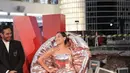 Gaun berbahan metalik tersebut menampilkan model strapless dengan siluet duyung yang menggembung di bagian bawah. Ditambah dengan aksen volume yang mengelilingi sekitar bahu-nya. [Fimela/Daniel Kampua].