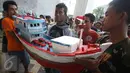 Nelayan yang tergabung dalam Koalisi Selamatkan Teluk Jakarta membawa miniatur kapal ketika mendatangi PTTUN di Cikini, Jakarta, Selasa (30/8). Mereka meminta hakim PTTUN menolak banding penerbitan izin reklamasi pulau G. (Liputan6.com/Immanuel Antonius)