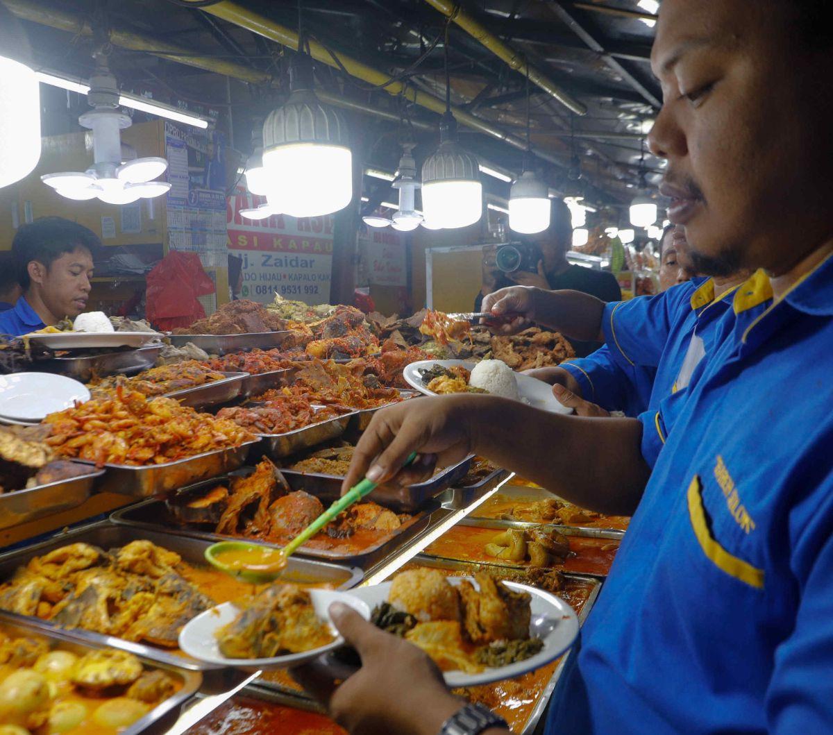 Pengunjung mengambil menu untuk buka puasa di Sentra kuliner Nasi Kapau di Jalan Kramat Raya, Jakarta, Kamis (14/3/2024). Lokasi kuliner yang berada di kawasan Senen ini menjadi tempat favorit para pencinta makanan khas Sumatera Barat.&nbsp;Foto: Liputan6.com