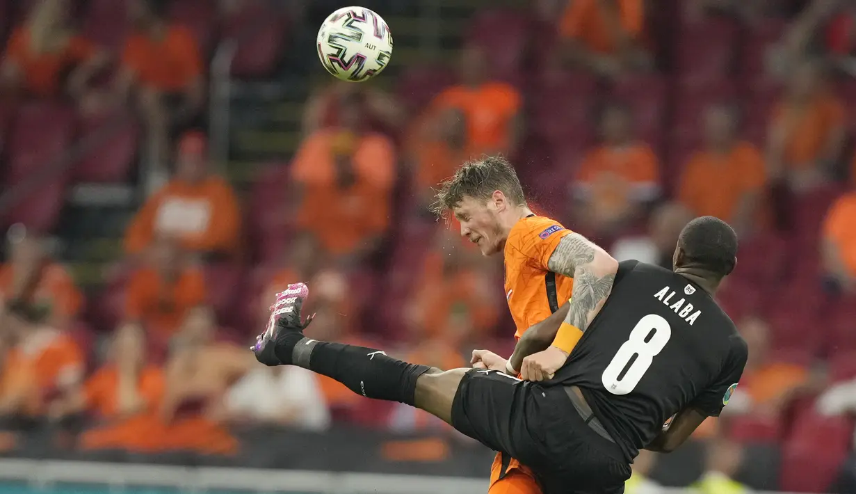 Bek timnas Austria, David Alaba berebut bola dengan penyerang Belanda, Wout Weghorst pada laga kedua Grup C Euro 2020 di Johan Cruijff Arena, Amsterdam, Jumat (18/6/2021) dini hari WIB. Tuan rumah Belanda berhasil mengalahkan Austria 2-0. (AP Photo/Peter Dejong, Pool)