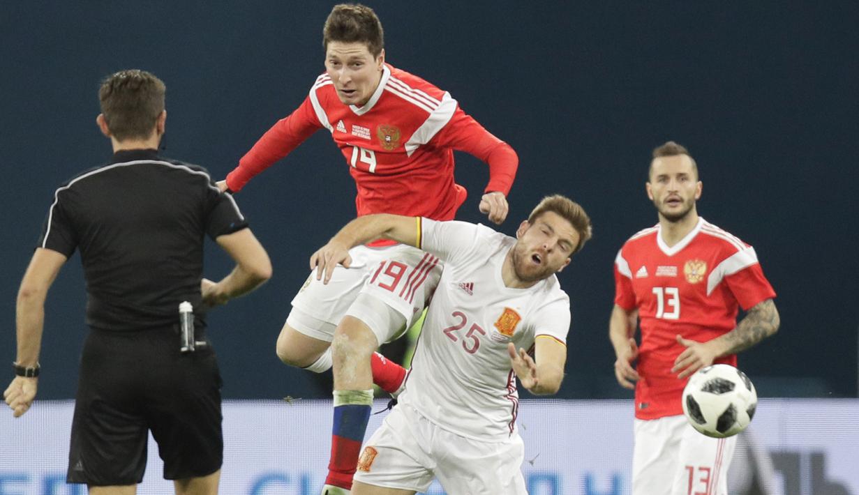 Pemain Rusia, Daler Kuzyayev (atas) berebut bola dengan pemain Spanyol, Asier Illarramendi pada laga persahabatan di St.Petersburg, Russia, (14/11/2017). Spanyol bermain imbang 3-3 lawan Rusia. (AP/Dmitri Lovetsky)