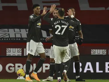 Penyerang Manchester United, Marcus Rashford (kiri) berselebrasi dengan rekannya usai mencetak gol ke gawang Sheffield United pada pertandingan Liga Inggris di stadion Bramall Lane di Sheffield, Inggris, Jumat (18/12/2020). Rashford mencetak dua gol dan mengantar MU menang 3-2. (AP Photo/Rui Vieira)