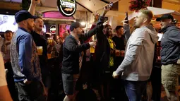 Pendukung Liverpool bernyanyi dan mendukung tim mereka di sebuah pub di alun-alun Campo de 'Fiori Roma, Italia (1/5). Liverpool akan menghadapi AS Roma di leg kedua semifinal Liga Champions. (AP Photo/Andrew Medichini )