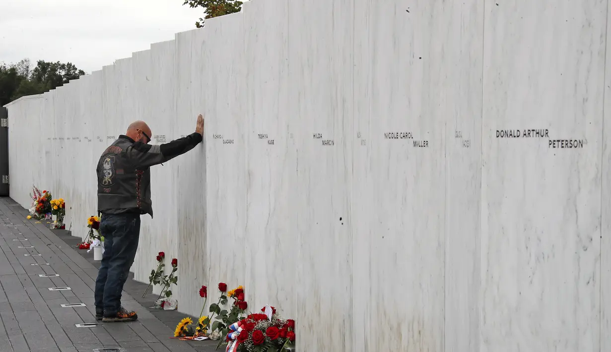 File foto 11 September 2018 ini, seorang pengunjung Flight 93 National Memorial di Shanksville, Pa., Memberi penghormatan di Wall of Names setelah Service of Remembrance, saat negara tersebut menandai peringatan 17 tahun peringatan Serangan 11 September 2001. (AP Photo/Gene J. Puskar)