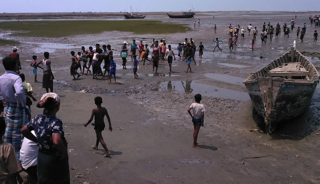 Warga menggotong mayat warga minoritas Muslim Rohingya yang tewas setelah perahu yang mereka tumpangi tenggelam di lepas pantai Negara Bagian Rakhine, Myanmar, Selasa (19/4). Sedikitnya 21 orang termasuk sembilan anak tewas. (STR/AFP)