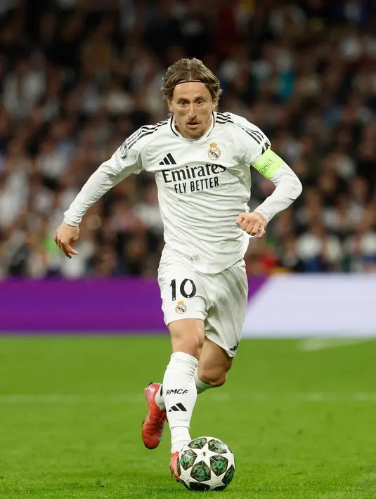 <p>Luka Modric akan meninggalkan Real Madrid setelah Piala Dunia Antarklub yang akan dimulai pada 18 Juni 2025 di Amerika Serikat. Tampak dalam foto, gelandang Real Madrid asal Kroasia, Luka Modric mengontrol bola saat pertandingan sepak bola leg kedua perempat final Liga Champions melawan Arsenal di Stadion Santiago Bernabeu, Madrid pada 16 April 2025. (Pierre-Philippe MARCOU/AFP)</p>