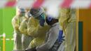 Petugas kesehatan mengumpulkan sampel usap (swab) untuk pengujian COVID-19 dari para pekerja yang siap kembali bekerja di pusat penapisan (screening) regional di Singapura (10/6/2020). (Xinhua/Then Chih Wey)