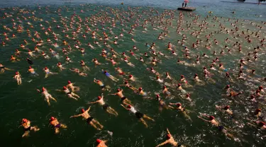 Para peserta saat mengikuti lomba berenang menyeberangi Danau Zurich, Swiss (24/8). Lomba sejauh 1,5 km ini diikuti oleh ratusan orang mulai dari anak muda hingga orang tua. (REUTERS/Arnd Wiegmann)