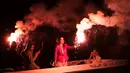 Sejumlah orang berada di atas kapal sambil menyalakan suar bersiap membakar patung Yudas saat perayaan tradisi Paskah kuno di semenanjung Peloponnese, Yunani (8/4). (AP/Petros Giannakouris)