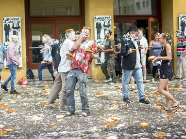 Peserta saling menyerang dengan kue pai saat mengikuti acara "pie fight" di Berlin, Jerman, 19 Juni 2015. Acara ini diselenggarakan oleh sebuah bioskop di Jerman. (REUTERS/Hannibal Hanschke)