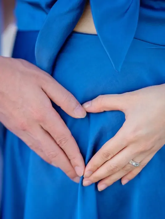 Tampak baby bump-nya yang mulai terlihat saat melakukan pose heart symbol. [@valenciatanoe]