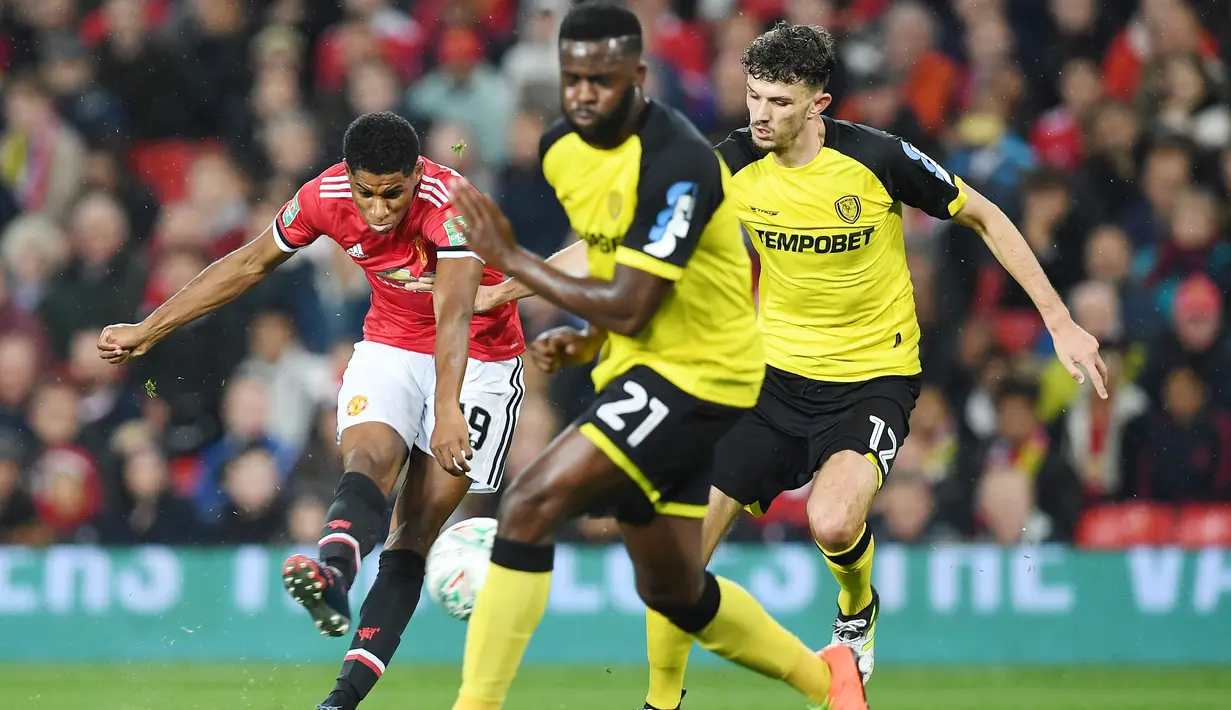 Sepakan pemain Manchester United, Marcus Rashford (kiri) menembus pertahanan Burton Albion pada laga Piala Liga Inggris di Old Trafford, Manchester (20/9/2017). MU menang 4-1. (AFP/Paul Ellis)
