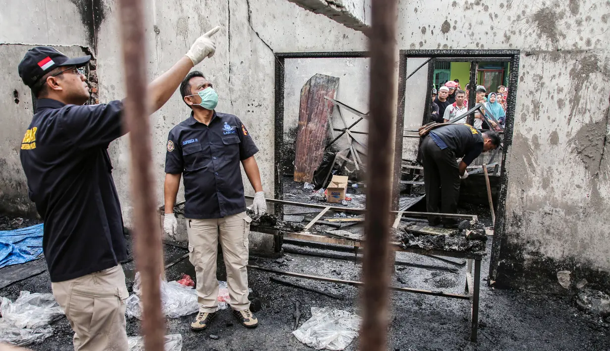 Tim penyelidik bekerja di lokasi kebakaran pabrik korek gas di Binjai, Langkat, Sumatera Utara, (21/6/2019). Kebakaran terjadi terjadi sekitar pukul 12.00 WIB diawali suara ledakan dari sekitar lokasi kejadian. (Ivan Damanik/AFP)