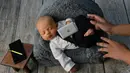 Seorang bayi yang baru lahir saat menjalani sesi foto di Banda Aceh pada 18 November 2019. Merekam momen bayi baru lahir lewat fotografi belakangan sedang menjadi tren para orangtua baru di Indonesia. (Photo by CHAIDEER MAHYUDDIN / AFP)