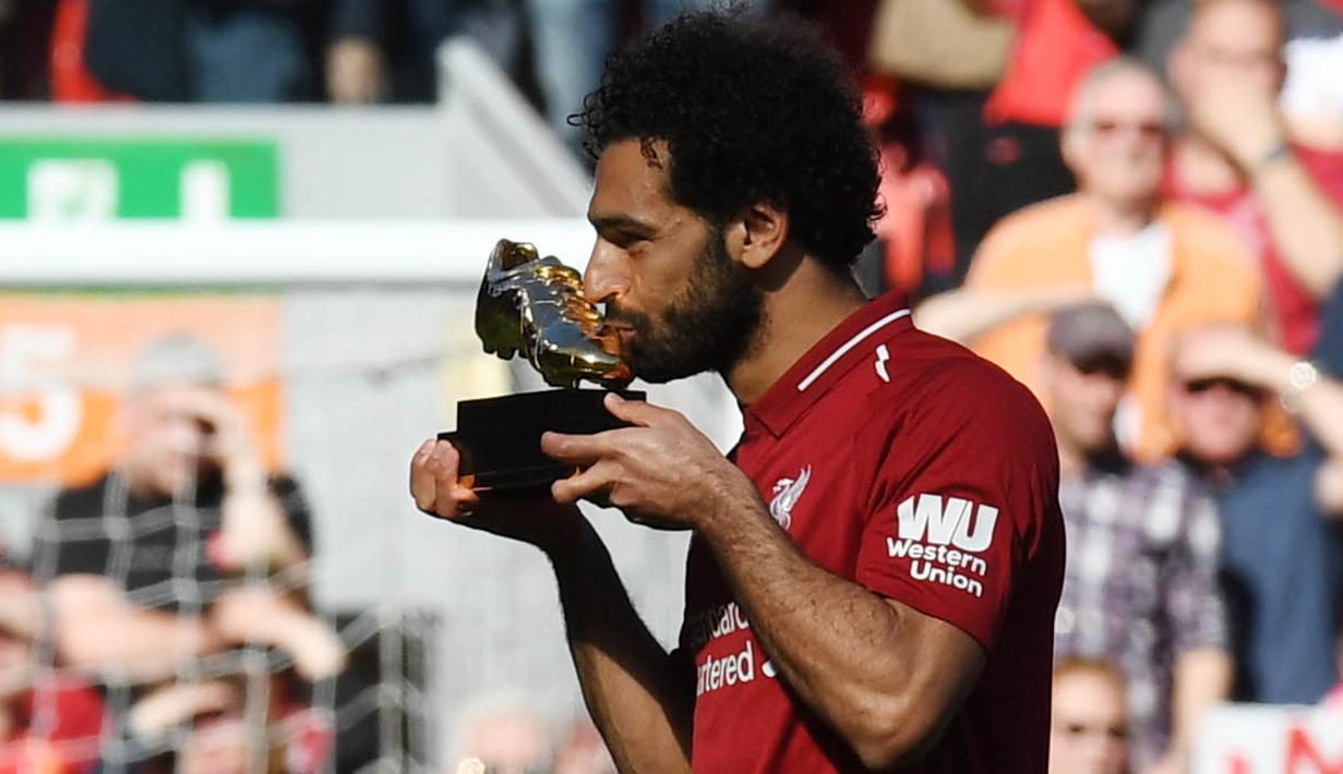 Penyerang Liverpool, Mohamed Salah, mencium trofi Sepatu Emas Premier League usai laga melawan Brighton & Hove Albion di Stadion Anfield, Minggu (13/5/2018). Salah menjadi top scorer Premier League musim ini dengan raihan 32 gol. (AFP/Paul Ellis)