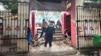 Petugas DPUPR Kota Depok membuat tangga sebagai akses jalan dari trotoar menuju SDN Pondok Cina 1, Kecamatan Beji, Kota Depok. (Liputan6.com/Dicky Agung Prihanto)