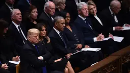 Presiden AS Donald Trump duduk bersebelahan dengan mantan presiden Barack Obama, mantan presiden Bill Clinton dan mantan presiden Jimmy Carter dalam prosesi pemakaman kenegaraan George HW Bush di Washington, Rabu (5/12). (Brendan SMIALOWSKI/AFP)