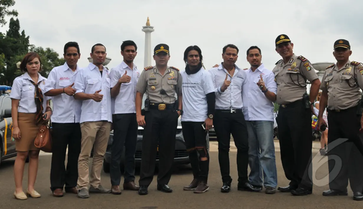 Komunitas Anak Bangsa berpose bersama petugas saat 'Aksi Maha Damai' di kawasan Monas, Jakarta, Selasa (3/2/2015). (Liputan6.com/Panji Diksana) 