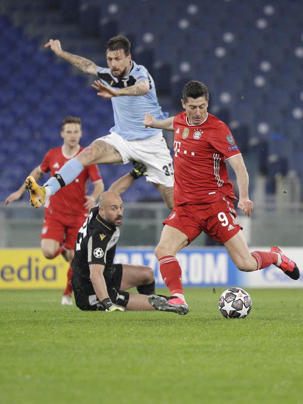 Penyerang Bayern Munchen, Robert Lewandowski (kanan) mencetak gol pembuka ke gawang Lazio dalam pertandingan leg pertama babak 16 besar Liga Champions, di Stadion Olimpico, Roma, Rabu (24/2/2021) dini hari WIB. Bayern Muenchen sukses meraih kemenangan 4-1 atas Lazio. (AP Photo/Gregorio Borgia)