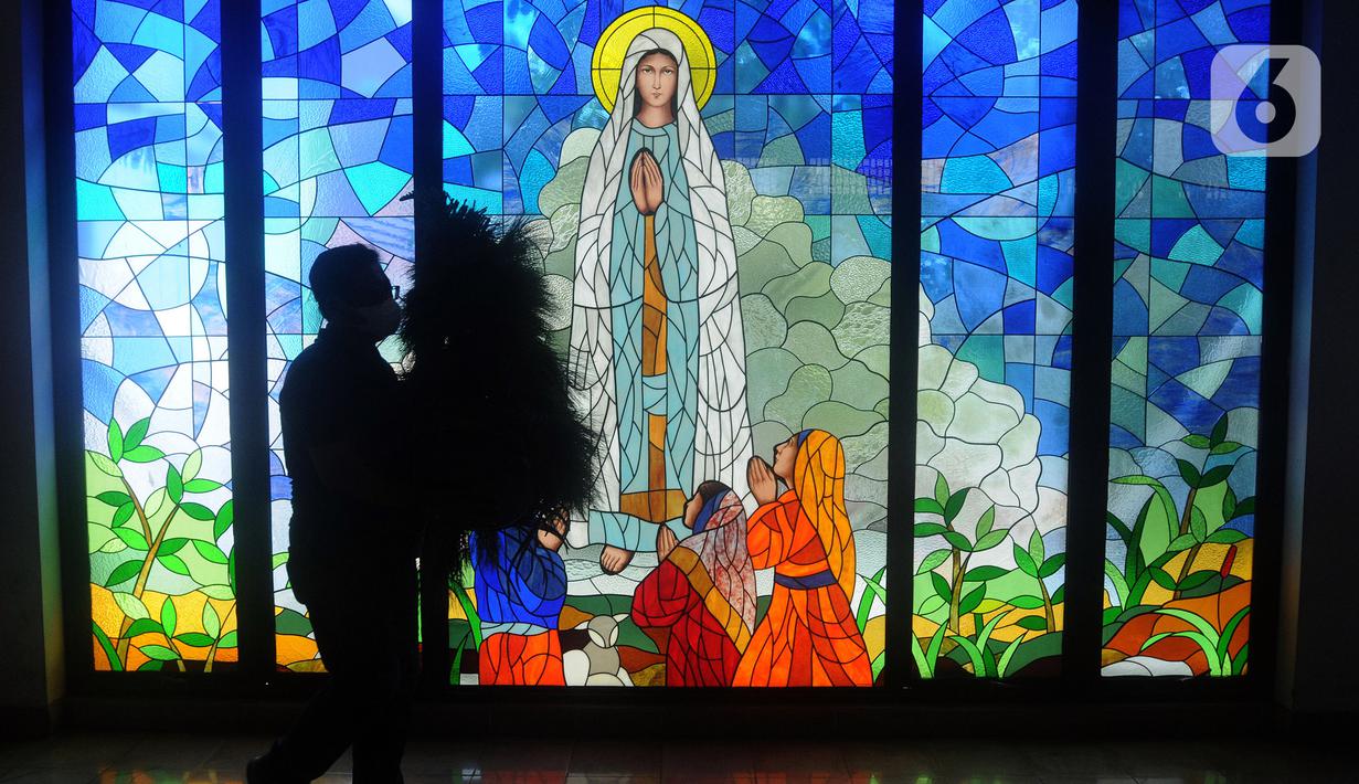 Umat Katolik membawa pohon yang akan dijadikan ornamen dekorasi Natal di Gereja Santo Barnabas, Tangerang Selatan, Banten, Kamis (23/12/2021). Sejumlah gereja di Indonesia mulai melakukan persiapan dan pemasangan dekorasi untuk menyambut misa dan perayaan Natal 2021. (merdeka.com/Arie Basuki)