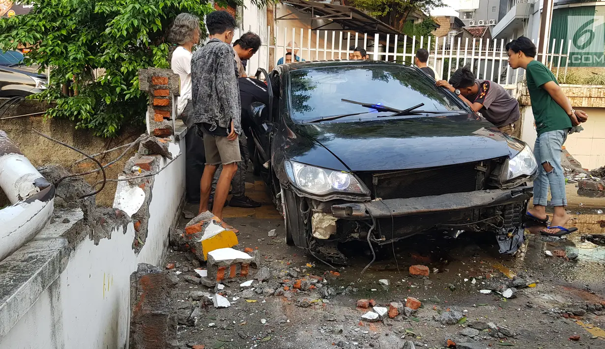 Warga melihat kondisi mobil yang mengalami kecelakaan tunggal di kawasan Pasar Minggu, Jakarta Selatan, Sabtu (8/6/2019). Mobil yang nyaris tercebur sungai itu dikendarai seorang pemuda yang nekat melakukan aksi kebut-kebutan saat jalanan ibu kota lengang. (Liputan6.com/Herman Zakharia)