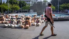 Seorang tentara Israel yang sedang tidak bertugas berjalan melewati instalasi boneka beruang raksasa dengan mata tertutup dan dihiasi foto warga Israel yang ditawan di Gaza di Tel Aviv, Israel, Rabu (25/10/2023). Instalasi tersebut dimaksudkan untuk menarik perhatian lebih dari 200 orang yang diculik oleh militan Hamas dalam serangan lintas batas pada 7 Oktober 2023. (AP Photo/Oded Balilty)