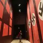 Pengunjung melintas dilorong bergambarkan bendera Nazi dan Soivet di Museum Perang Dunia 2 di Gdansk, Polandia, 23/1). Museum ini satu-satunya yang merekam sejarah Polandia saat Perang Dunia II. (AP/Czarek Sokolowski)