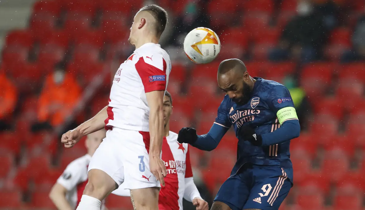 Penyerang Arsenal, Alexandre Lacazette melompat saat berebut bola dengan bek Slavia Praha, Tomas Holes pada leg kedua perempat final Liga Europa di Stadion Sinobo, Praha, Jumat (16/4) dini hari WIB.  Arsenal lolos ke semifinal Liga Europa setelah menang telak 4-0 di markas Slavia Praha. (AP Photo/Pe