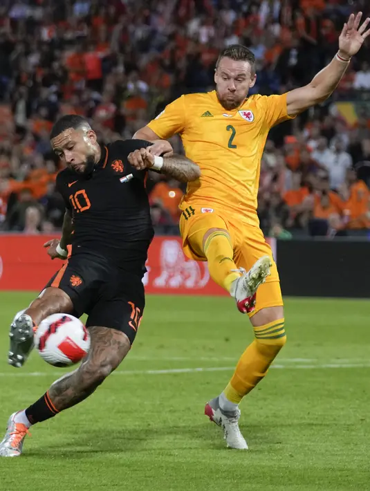 Pemain Belanda Memphis Depay (kiri) mencetak gol ke gawang Wales pada pertandingan sepak bola UEFA Nations League di Stadion De Kuip, Rotterdam, Belanda, 14 Juni , 2022. Belanda menang dengan skor 3-2. (AP Photo/Peter Dejong)