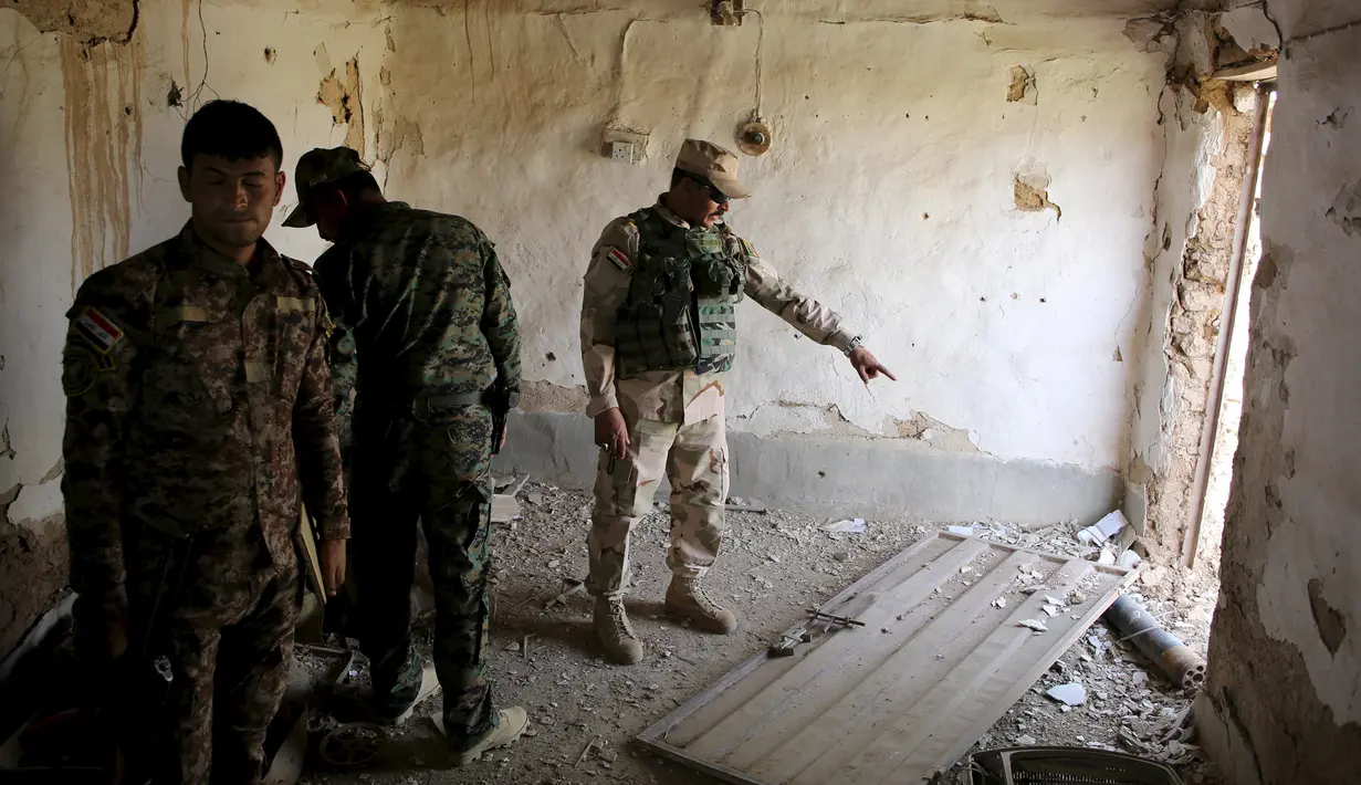 Sejumlah tentara Irak memeriksa sebuah bangunan yang diyakini bekas persembunyian ISIS di sebuah desa di Mahana, Mosul, Irak, Kamis (28/4). Tentara Irak berhasil mengalahkan Militan ISIS yang menguasai Mosul sejak Juni 2014. (REUTERS/Goran Tomasevic) 