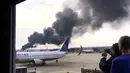 Warga mengabadikan pesawat American Airlines yang terbakar di Bandara O'Hare Chicago, Illinois, AS (28/10). Akibat kejadian tersebut Pilot pesawat dengan sigap segera membatalkan proses take-off. (Courtesy of Robocast.com/Handout via REUTERS)