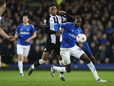 Gelandang Newcastle United Joe Willock berbeut bola dengan gelandang Everton Abdoulaye Doucoure pada lanjutan Liga Inggris di Stadion Goodison Park, Liverpool, Jumat (18/3/2022) dini hari WIB. Bertindak sebagai tuan rumah, Everton menang tipis 1-0.  (Richard Sellers/PA via AP)