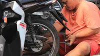 Mekanik memperbaiki motor di salah satu bengkel di Otista, Jakarta, Minggu (10/6). Calon pemudik motor mulai memenuhi bengkel guna menyervis atau mengganti suku cadang kendaraan sebelum digunakan untuk mudik Lebaran. (Liputan6.com/Angga Yuniar)